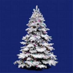 a white christmas tree with multi - colored lights against a dark blue background is shown