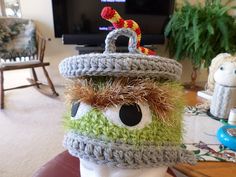 a crocheted hat with an eyeball on it and a fake horse in the background