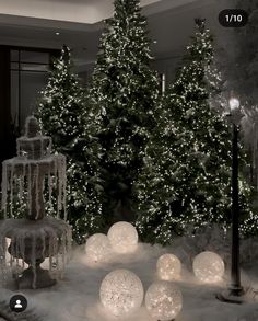 a christmas tree is surrounded by lights and snow balls in the middle of a room