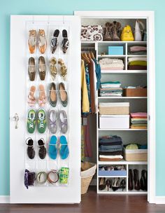 an open closet with shoes and other items on shelves next to a blue painted wall