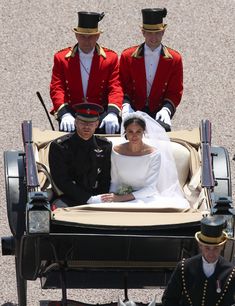 the bride and groom are riding in a horse drawn carriage with two guards on either side