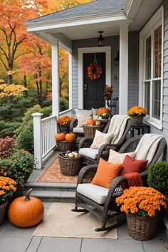 front porch decorated for fall with chairs and pumpkins