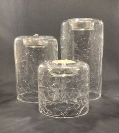 three clear glass jars with holes in them