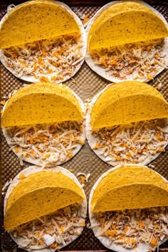 six tortillas with shredded cheese and toppings on a baking sheet, ready to go into the oven