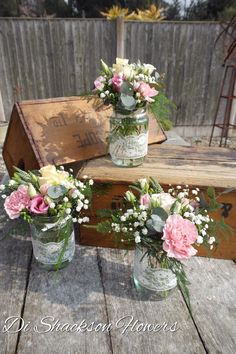 three mason jars filled with pink and white flowers