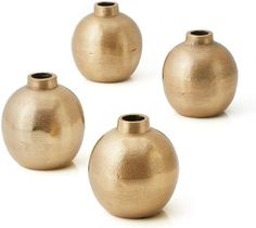 four gold colored vases sitting next to each other