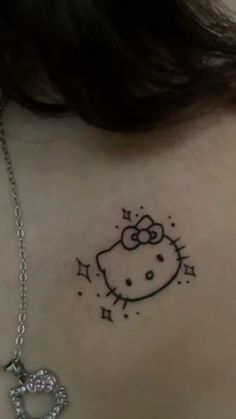 the back of a woman's neck with a hello kitty tattoo design on it