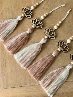 four tasseled necklaces with lotuses and beads on a wooden table top