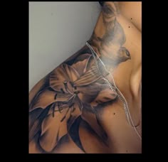 a woman's back with tattoos on her body and flowers in the middle of it