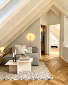 a living room filled with furniture under a loft style roof beam in an attic apartment