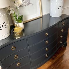 two vases are sitting on top of a dresser