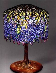 a table lamp that is made out of stained glass and has flowers on the base