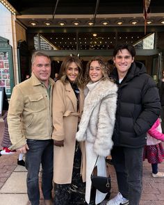 three people standing next to each other in front of a theater