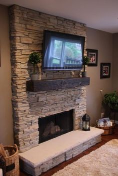 a living room with a tv mounted on the wall above a fire place and rug