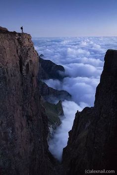 a person standing on top of a mountain above the clouds