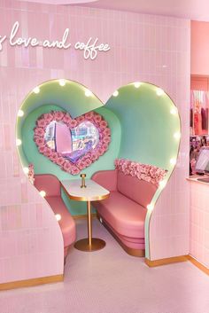 a pink and green booth with a heart shaped mirror