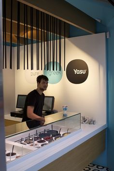 a man standing in front of a display case with sunglasses on it's sides