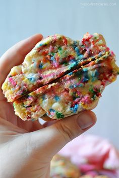 someone holding up a cookie with sprinkles on it