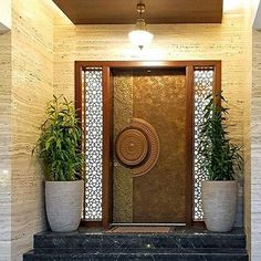 an entry way with potted plants on the steps and a decorative door in the center