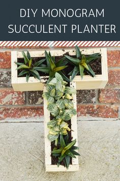 a wooden cross with plants growing in it and the words diy monogram succulent planter