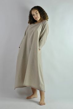 This is our no. 52 of Conscious Clothing Concept. This beautiful beige A-line loose fitting kaftan dress is made of pure quality linen. It is very comfortable to wear around the house or as the night dress. It works well as the summer beach dress protecting from the sun. It has got two pockets on the sides. Top and the bottom of the dress is machine embroided. It is the ultimate fabric for hot weather as it breathes and absorbs moisture better that any fabric on earth. Please write if you need d Beach Dresses With Pockets In Khaki, Khaki Beach Dresses With Pockets, Spring Beige Linen Dress With Pockets, Relaxed Fit Tunic Dress Unlined, Beige Summer Sleep Dress, Beige Lagenlook Dress For Spring, Oversized Long Sleeve Beige Tunic, Oversized Beige Long Sleeve Tunic, Spring Beige Lagenlook Dress