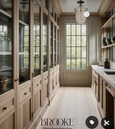 an empty kitchen with wooden cabinets and white counter tops, along with a large window