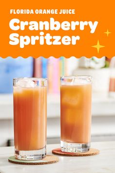 two glasses filled with orange juice sitting on top of a table