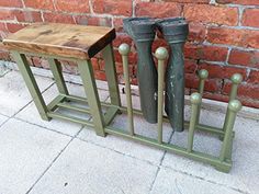 two green boots are sitting next to each other on the ground near a brick wall