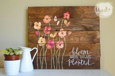 a wooden sign with flowers painted on it