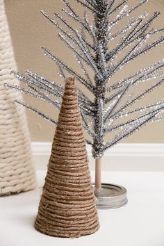 twine wrapped christmas trees are displayed on a table