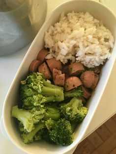 a white bowl filled with rice, broccoli and meat