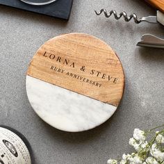 a personalized wooden coaster on top of a table next to flowers and other items