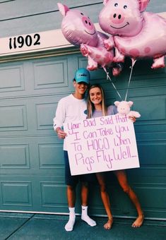 two people standing in front of a garage holding up pink pig balloons and a sign that says, your god said that you can take you to hoo when pigs fly