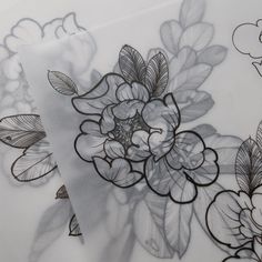 an artistic drawing of flowers and leaves on a white sheet with black outline work in the middle