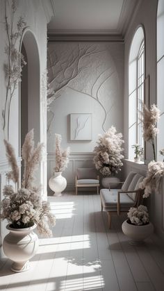 a room filled with lots of white furniture and flowers in vases on the floor