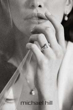 black and white photograph of a woman wearing a veil with her hand on her face