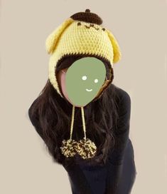 a woman wearing a knitted hat with a smiley face on it's head