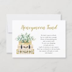 a card with the words honeymoon fund written in gold foil on it and a suitcase filled with flowers