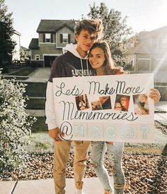 a man and woman standing next to each other holding a sign that says let's make more memories