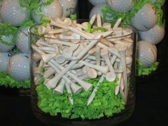 golf balls and tees are arranged in a glass bowl on a black table top