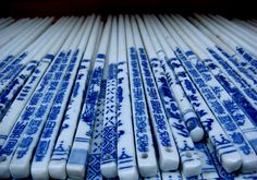 many blue and white chopsticks are stacked on top of each other in rows