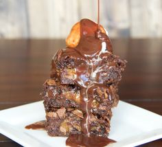 a piece of brownie with caramel on top and drizzled in chocolate