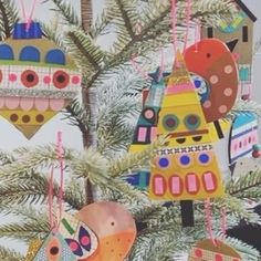 colorful ornaments hanging from a christmas tree in the shape of houses and boats on them