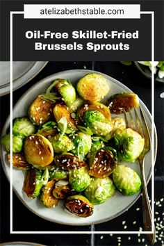 a white plate topped with brussel sprouts covered in sesame seeds and sauce