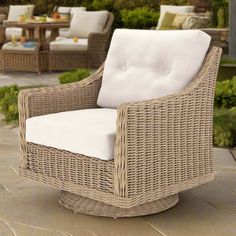 a wicker chair sitting on top of a stone patio