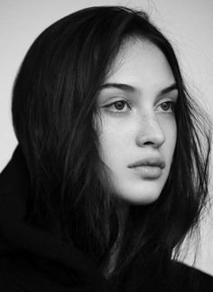 a black and white photo of a woman with long dark hair wearing a hoodie