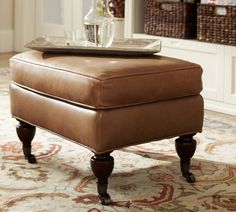 a brown ottoman sitting on top of a rug