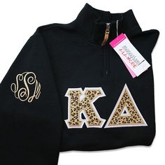 a black sweatshirt with gold letters and leopard print on the front, along with a name tag