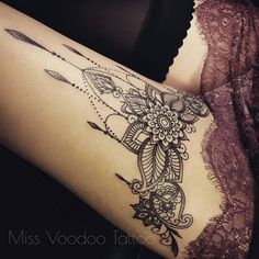 a woman's thigh with an intricate tattoo design on her leg and the arm