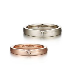 two wedding bands, one with a diamond and the other with an arrow on it